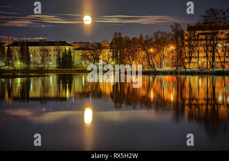 Stadtbild von Hämeenlinna in Finnland in der Mondnacht. Reflexionen von Citylights auf die noch Wasser des Sees. Stockfoto