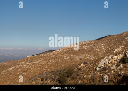 Warmes Licht des späten Nachmittags. Details eines Berges mit Steinen und Felsen und wenig Vegetation. Blue Sky. Eine der umliegenden Berge Lasith Stockfoto