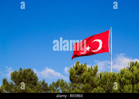 Türkische Flagge schwenkten im blauen Himmel Stockfoto