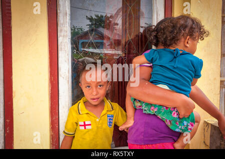 Mutter mit Kindern warten auf den Regen zu stoppen. Flores ist eine der Kleine Sunda Inseln, einer Inselgruppe in der östlichen Hälfte von Indonesien. Stockfoto