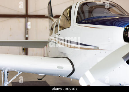 Kleine weiße und blaue Flugzeug im Hangar, kleinen Cockpit, private, Blick auf den Seitenflügel und Cockpit Tür Stockfoto