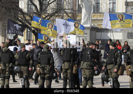 Kiew, Kiew, Ukraine. 8 Mär, 2019. Rechtsextremen Aktivisten sind gesehen Holding flags vor Polizisten stehen auf Guard während des Protestes. ukrainischen Feministinnen und ihren Anhängern ihre März anspruchsvolle für die Rechte der Frauen weltweit und gegen häusliche Gewalt bei den Internationalen Frauentag, der jedes Jahr gefeiert wird am 8. März statt. Credit: Pavlo Gontschar/SOPA Images/ZUMA Draht/Alamy leben Nachrichten Stockfoto