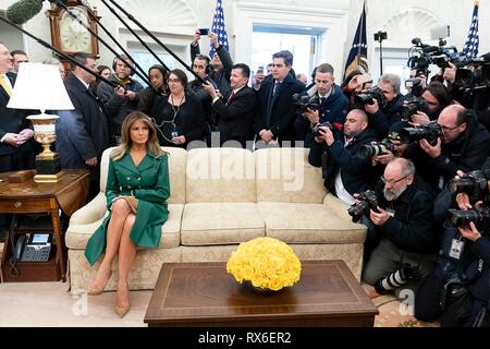 Us-First Lady Melania Trump, trug ein grünes Leder double-breasted Mantel Kleid sitzt durch Kameras bei einem bilateralen Treffen zwischen Präsident Donald Trump und der tschechische Premierminister Andrej Babis im Oval Office des Weißen Hauses März 7, 2019 in Washington, DC, umgeben. Stockfoto