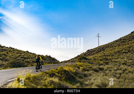 Bateria de Castillitos, Spanien - 28. Februar - 2019: Weibliche Mountainbike Radfahrer bergauf entlang der Bergstraße in Spanien Stockfoto