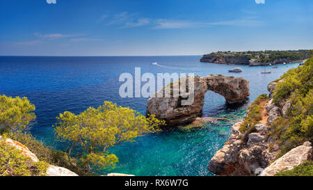 Es Pontas auf Mallorca mit Boot in der Nähe des Mittelmeers verankert. Sonnigen Tag mit Yacht und rock Arch in der Nähe von Santanyi Mallorca Stockfoto