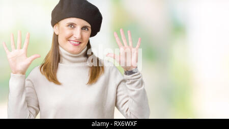 Reife Frau mittleren Alters tragen winter Pullover und Baskenmütze über isolierte Hintergrund angezeigt und zeigen mit den Fingern Nummer zehn, während lächelnd confid Stockfoto