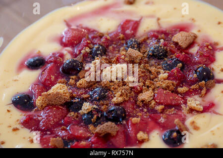 Hausgemachten Tomatensuppe mit Vanillesauce, Erdbeeren, Heidelbeeren und zerbröselten Keksen Stockfoto