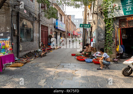 Juli 2016 - Luoyang, China - Die kleine Straße, die durch die antike Stadt Luoyang läuft, voller Zeichen von Läden, die Kunst und die Art des Materials. Stockfoto