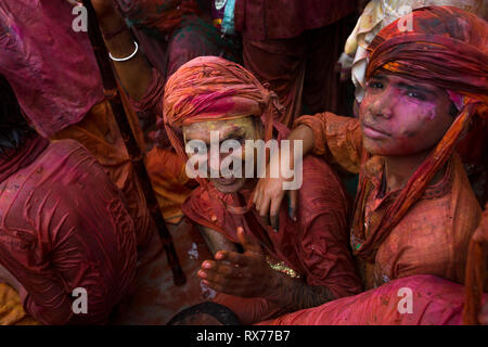 Während Holi Festival singt Abgesandte Gruppe in der Mitte des Tempels, während andere farbige Pulver und Wasser werfen würde Stockfoto