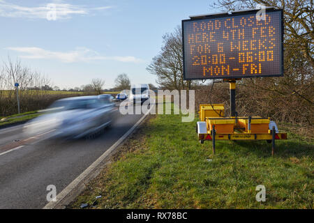 Straßensperrung unterzeichnen, Nettleham, Lincoln mit Verkehr Stockfoto