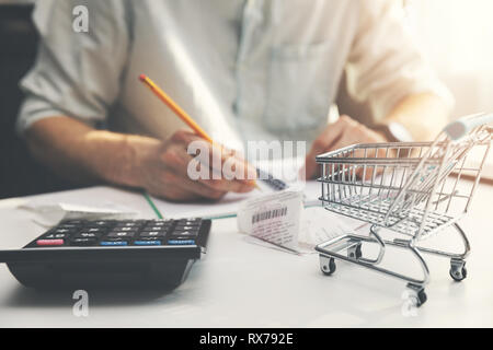 Familie Budgetplanung - Mann zählen und prüfen Haushalt tägliche Kosten Stockfoto