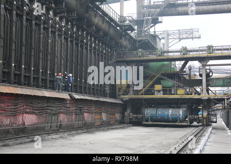 Blick auf Werk Slums mit Metallgehäuse und Maschinen für die Produktion der Kokerei Industrie, offenem Feuer und Rauch Bildschirm in einem Werk in der Ukraine Stockfoto