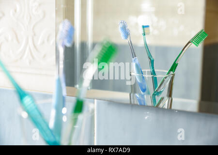 Zahnbürsten in Vase im Glas ein Badezimmer wider. Horizontale Komposition. Vorderansicht. Stockfoto