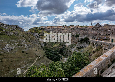 MATERA, Italien - 27. AUGUST 2018: Sommer Tag Landschaft Straße Blick auf die herrliche alte Stadt der Sassi mit weißen geschwollene Wolken ziehen auf dem Italienischen Stockfoto