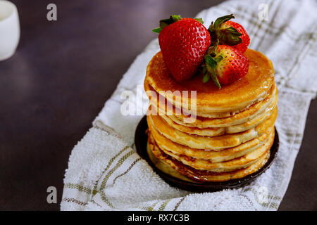 Pfannkuchen mit Erdbeeren, Beeren und Sirup auf Holz- Hintergrund Stockfoto