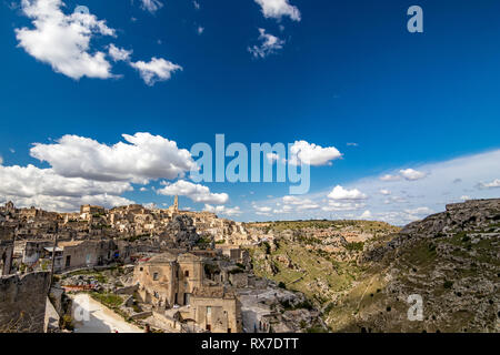 MATERA, Italien - 27. AUGUST 2018: Warme Landschaft Sommer Tag Aussicht auf die beeindruckende antike Stadt des berühmten Sassi mit weißen geschwollene Wolken, die auf der IT Stockfoto