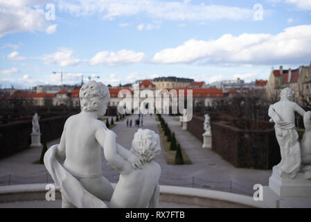 Das Schloss Belvedere und Gärten Wien - Untere Belvedere Palace aus dem unteren Gärten mit einer Steinstatue der Kinder in den Vordergrund Stockfoto