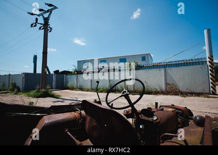 Abgebrochene vintage rusty Traktor auf Hinterhof. Rostige Stück Stahl Maschinen. Stockfoto
