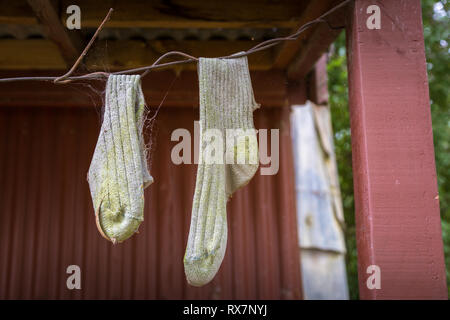 Paar alte Socken auf einer Linie, mit Spinnweben Stockfoto