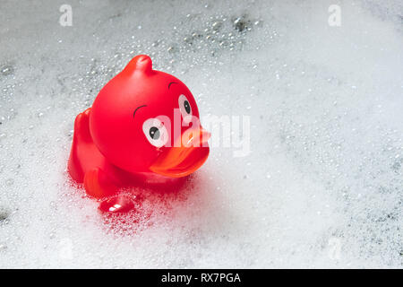 Rot Spielzeug badeente unter den Seifenblasen in die Badewanne
