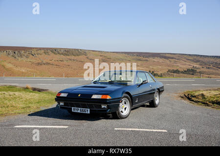 Ferrari 400 durch einen Feldweg in der Derbyshire Peak District an einem sonnigen Tag geparkt Stockfoto