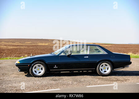 Ferrari 400 durch einen Feldweg in der Derbyshire Peak District an einem sonnigen Tag geparkt Stockfoto