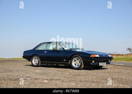 Ferrari 400 durch einen Feldweg in der Derbyshire Peak District an einem sonnigen Tag geparkt Stockfoto