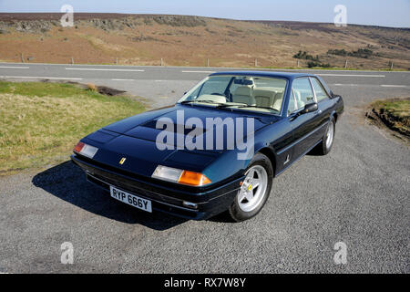 Ferrari 400 durch einen Feldweg in der Derbyshire Peak District an einem sonnigen Tag geparkt Stockfoto