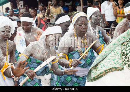 Bassam, Côte d'Ivoire - November 7, 2015: Frauen in Grün loincloths gekleidet, Kaolin auf ihren Körpern, mit Kragen und Schals auf dem Kopf tanzen Stockfoto