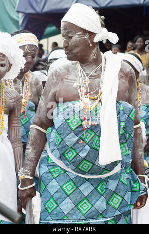 Bassam, Côte d'Ivoire - November 7, 2015: Afrikanische Frauen in Loincloths gekleidet, caolin auf den Körper und die weiße Tücher auf dem Kopf sind in Zeilen zu Acco Stockfoto