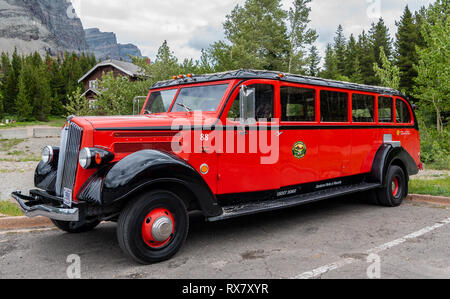 Gletscher Natoinal Park, Vereinigte Staaten: Geparkten roten Jammer wartet auf eine Gruppe zu einem Rundgang durch die malerische Glacier National Park Stockfoto