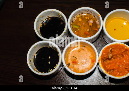 Verschiedene Arten von Soße auf asiatische Restaurants auf kleine Schalen in einer Reihe angeordnet Stockfoto