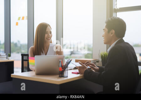 Business Kollegen zufrieden Geschäftsmann und geschäftsfrau am Schreibtisch in einem Büro sitzen Stockfoto