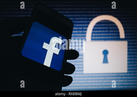 Facebook Symbol, Logo auf dem Smartphone angezeigt wird, öffnen Sie sperren, Zahlen null, eins als Textur, blauen Gradienten Unschärfe im Hintergrund Stockfoto