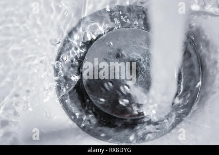 Closeup bad Abfluss im Waschbecken mit fließendem Wasser Stockfoto