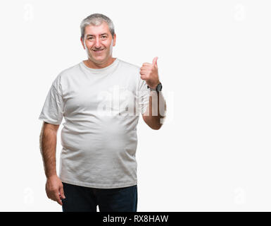 Gut aussehender älterer Mann über isolierte Hintergrund lächelnd mit glücklichen Gesicht und zeigt auf die Seite mit dem Daumen nach oben. Stockfoto