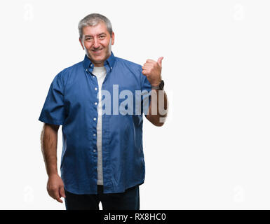 Gut aussehender älterer Mann über isolierte Hintergrund lächelnd mit glücklichen Gesicht und zeigt auf die Seite mit dem Daumen nach oben. Stockfoto
