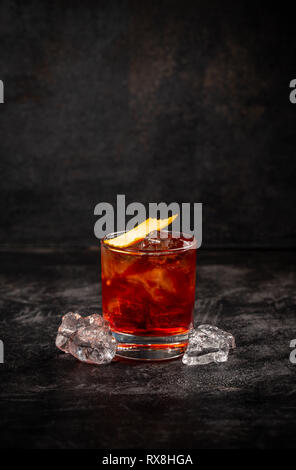 Negroni Cocktail mit Orange Peel auf dunklem Hintergrund eingerichtet Stockfoto