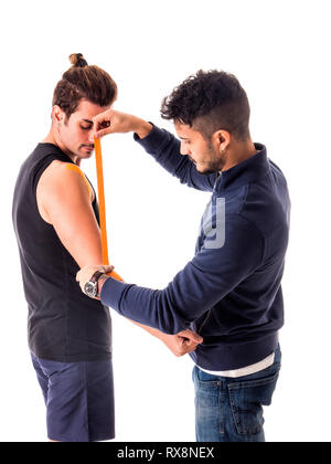 Der Mann klebt Kinesio-Bänder auf die Arme des Sportlers Stockfoto