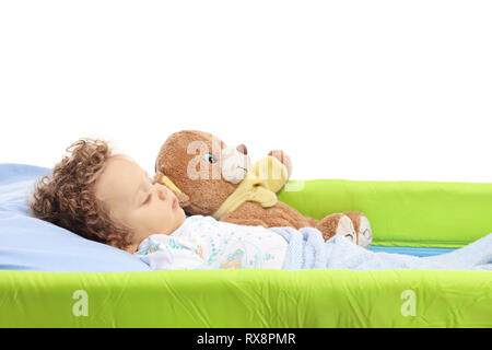 Baby Schlafsack mit seinem Teddybären in einem Kinderbett auf weißem Hintergrund Stockfoto