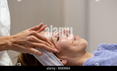 Profil anzeigen von junge Frau auf die Massagebank, entspannende und regenerierende Gesichtsbehandlung. Stockfoto