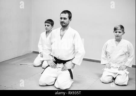 Kinder im Kimono beginnen Ausbildung auf Aikido. Stockfoto