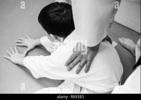 Kinder im Kimono beginnen Ausbildung auf Aikido. Stockfoto