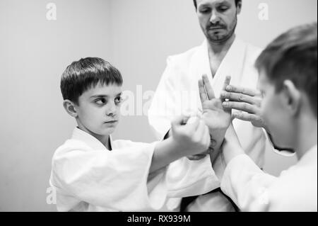 Kinder im Kimono beginnen Ausbildung auf Aikido. Stockfoto