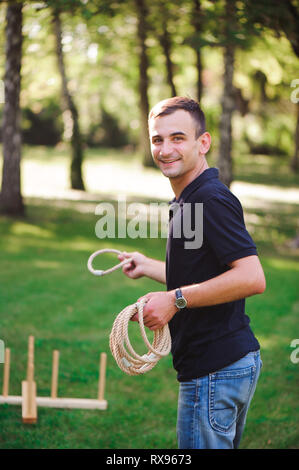 Junge spielt ein Spiel Abwurfringe im Freien im Sommer Park Stockfoto