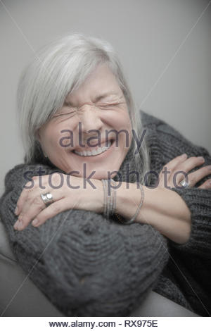 Portrait verspielt, gerne ältere Frau, die mit dem grauen Haar lachend