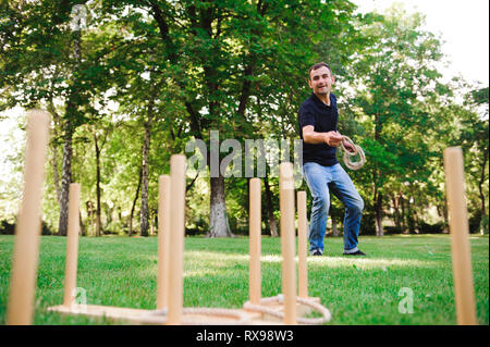Junge spielt ein Spiel Abwurfringe im Freien im Sommer. Stockfoto