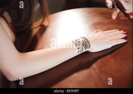 Künstler, die Anwendung von Henna-Tattoo auf Frauen Hände. Mehndi ist die traditionelle indische dekorative Kunst. Close-up Stockfoto