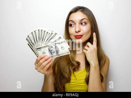 Junge, hübsche Frau im gelben Kleid mit Bündel geld Banknoten, suchen Sie auf weißem Hintergrund Stockfoto