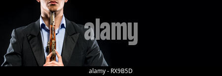 7/8 Bild horizontal Mann mit blauem Hemd schwarz formale eleganten Anzug Holding in den Händen Waffe Muskete in der Nähe des Halses, töten sich Selbstmord Konzept, cop Stockfoto